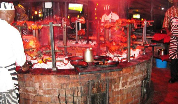 "Guests enjoying a traditional barbecue feast at the famous Carnivore Restaurant in Nairobi during a city tour
